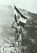 Ein Askari mit Reichsflagge in Gisenyi.